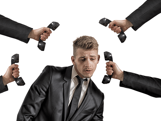 A man surrounded by many telephones