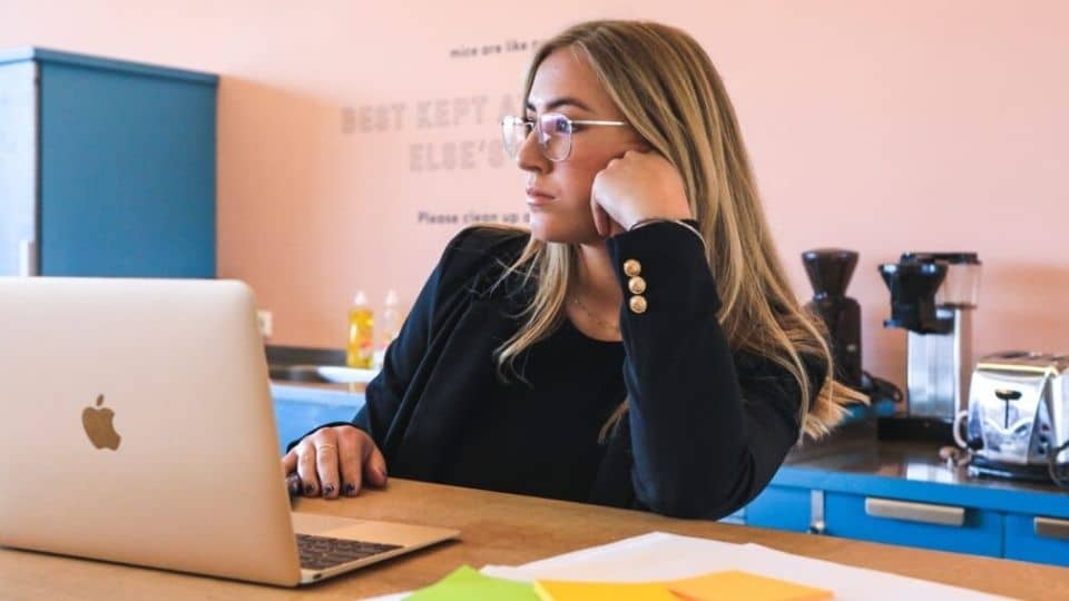 Lady at desk looking past her laptop in office